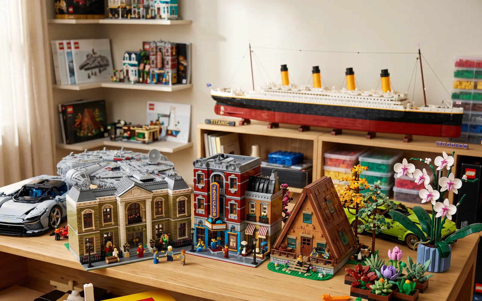 A room of built LEGO sets: modular buildings, a supercar and the Titanic, with LEGO boxes on the shelves behind